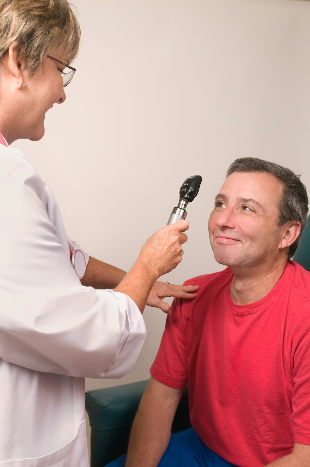 An ophthalmologist examining a patients eye with an ophthalmoscope